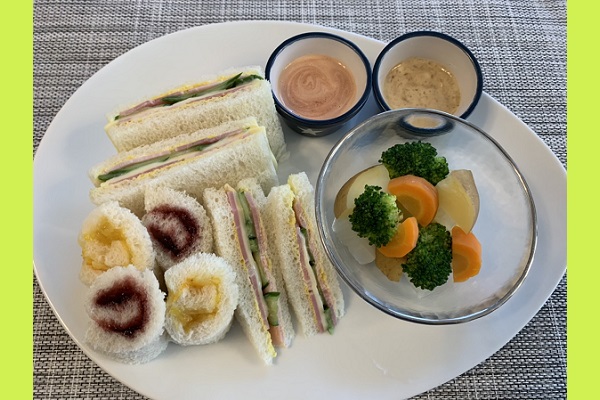 三角サンドイッチと長方形のサンドイッチとくるくるサンド、その横ににんじんやブロッコリーの温野菜