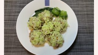 白いお皿にレンチンキャベツシューマイが6個と付け合わせで濃い緑のチンゲン菜