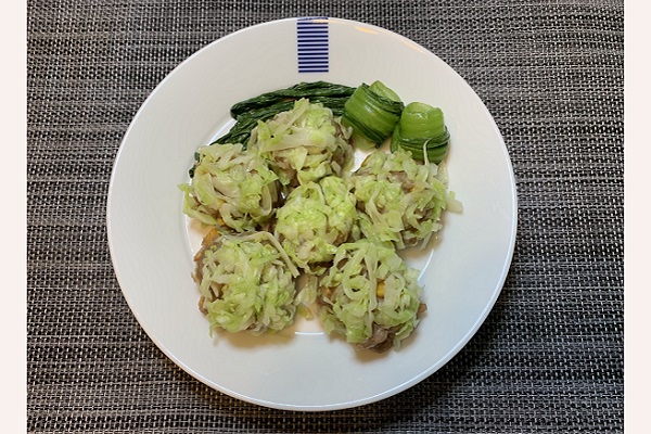 白いお皿にレンチンキャベツシューマイが6個と付け合わせで濃い緑のチンゲン菜