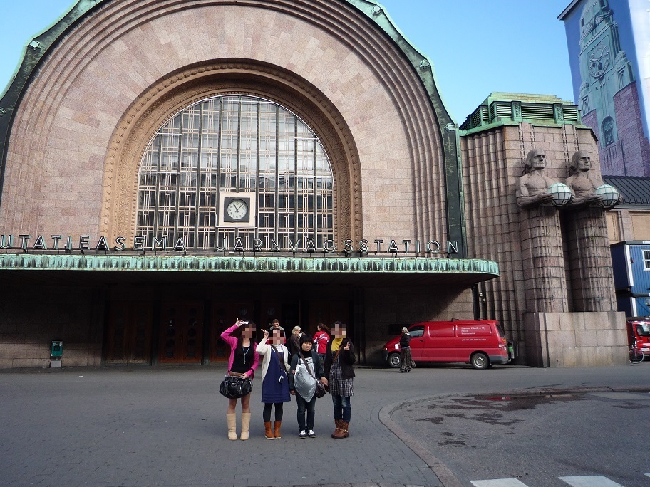 ヘルシンキ中央駅正面入り口前でポーズを取る4人の女子学生